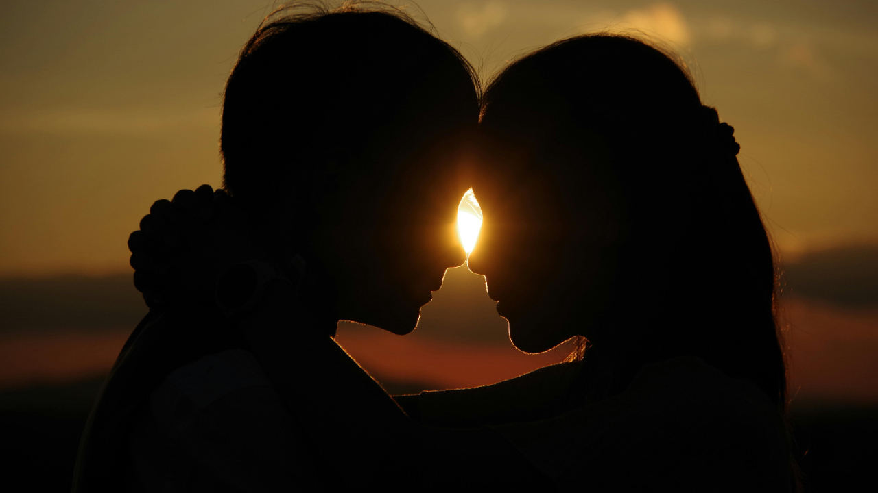 Silhouette of a husband and wife touching foreheads at sunset, symbolizing emotional connection, affection, and intimacy in marriage.