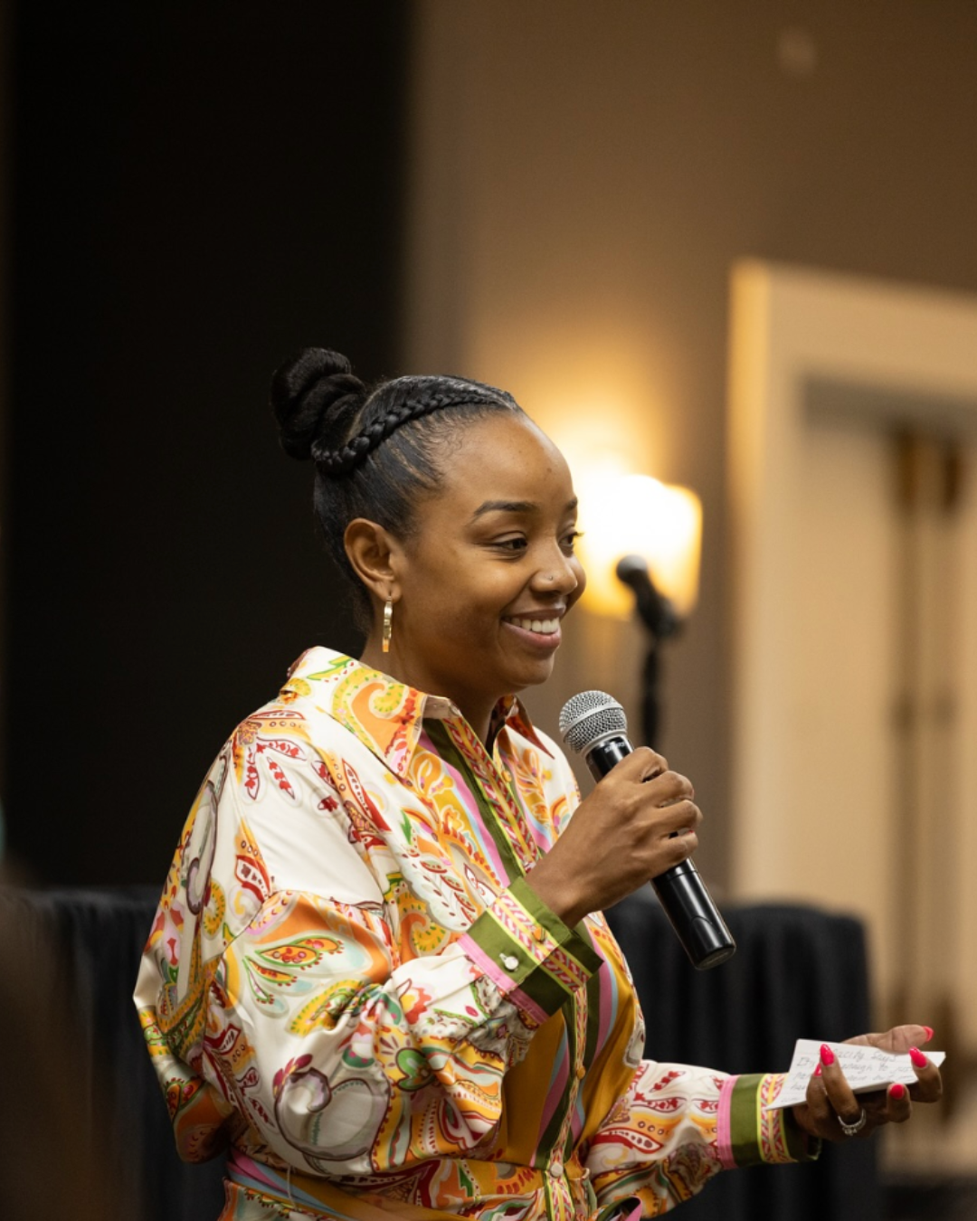 RaQuel Hopkins speaking with a handheld microphone