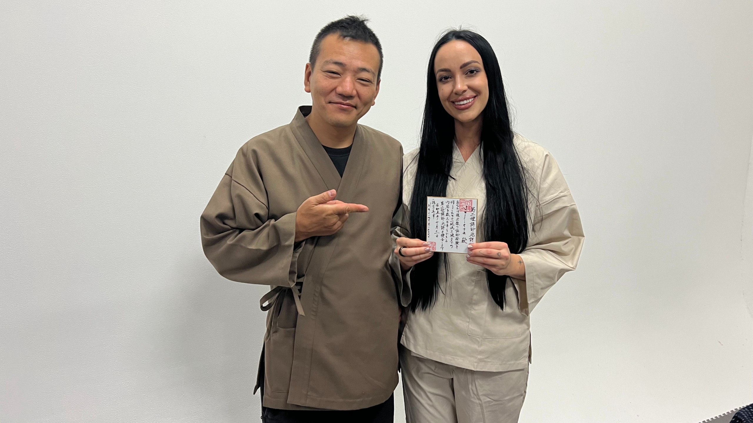 julieta chiara holding her shibari license with master hajime kinoko