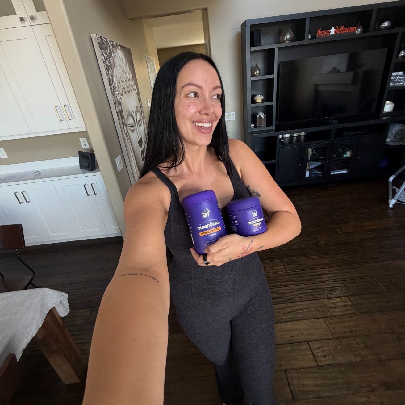 Julieta chiara holding two tubs of moonbrew sleep supplement