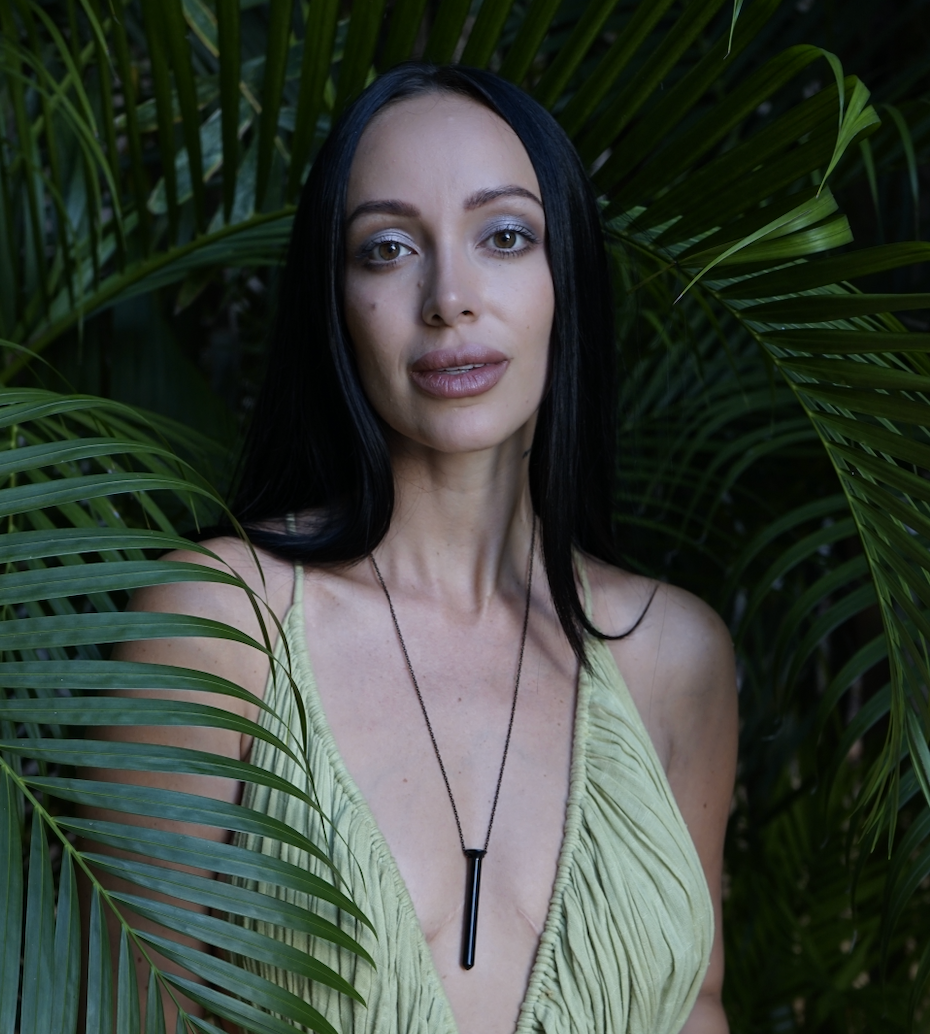 Headshot of Julieta chiara in a jungle background wearing a green dress and vibrator necklace