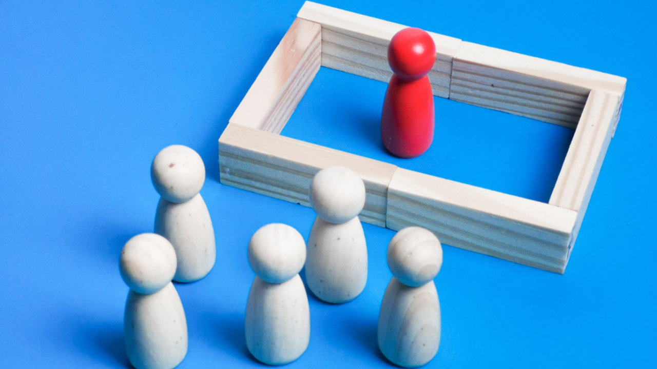 A red peg in a square barrier, separated from other white pegs
