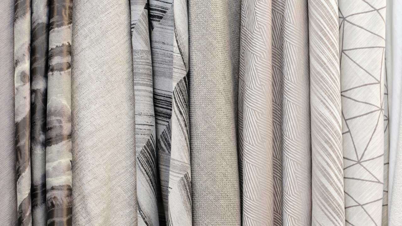 Collection of neutral fabrics hanging side by side.