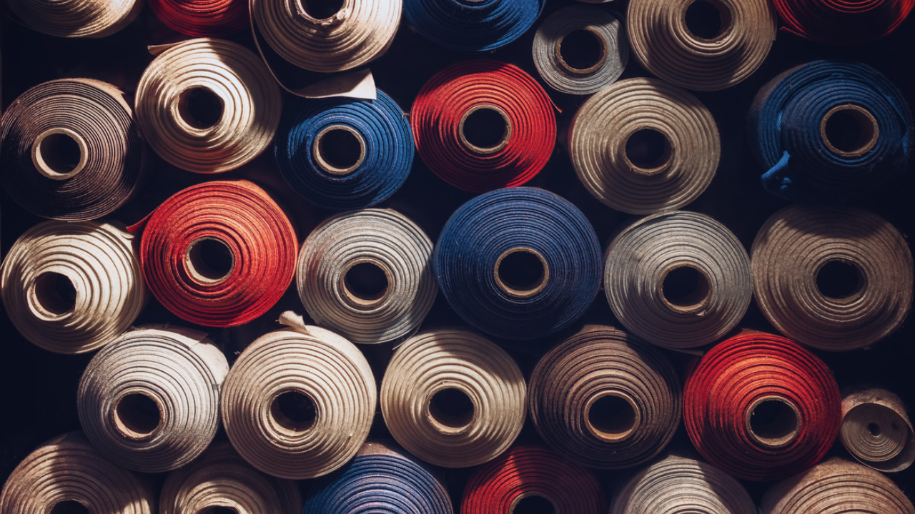 Detail of red white and blue fabric rolls stacked.