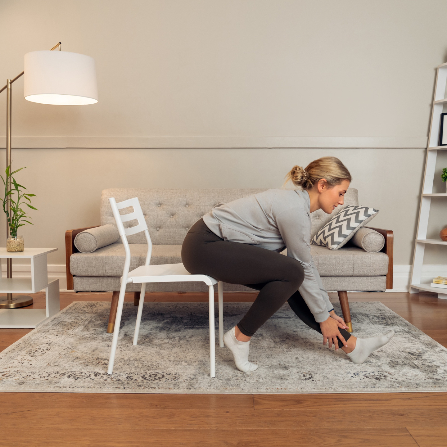 Justine stretching while sitting in a chair in a seated mobility routine.