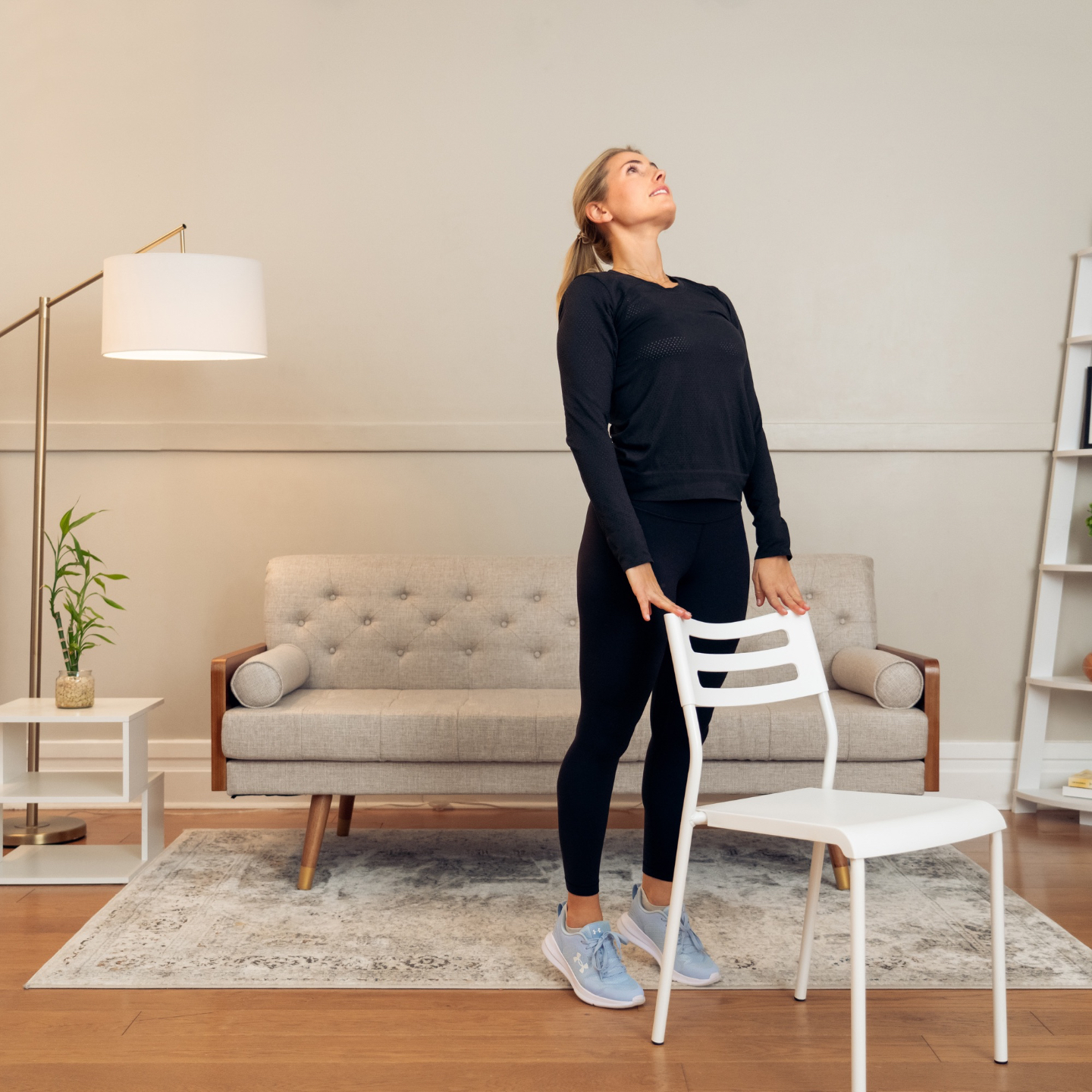 Justine stretching with chair support during a beginner mobility routine.