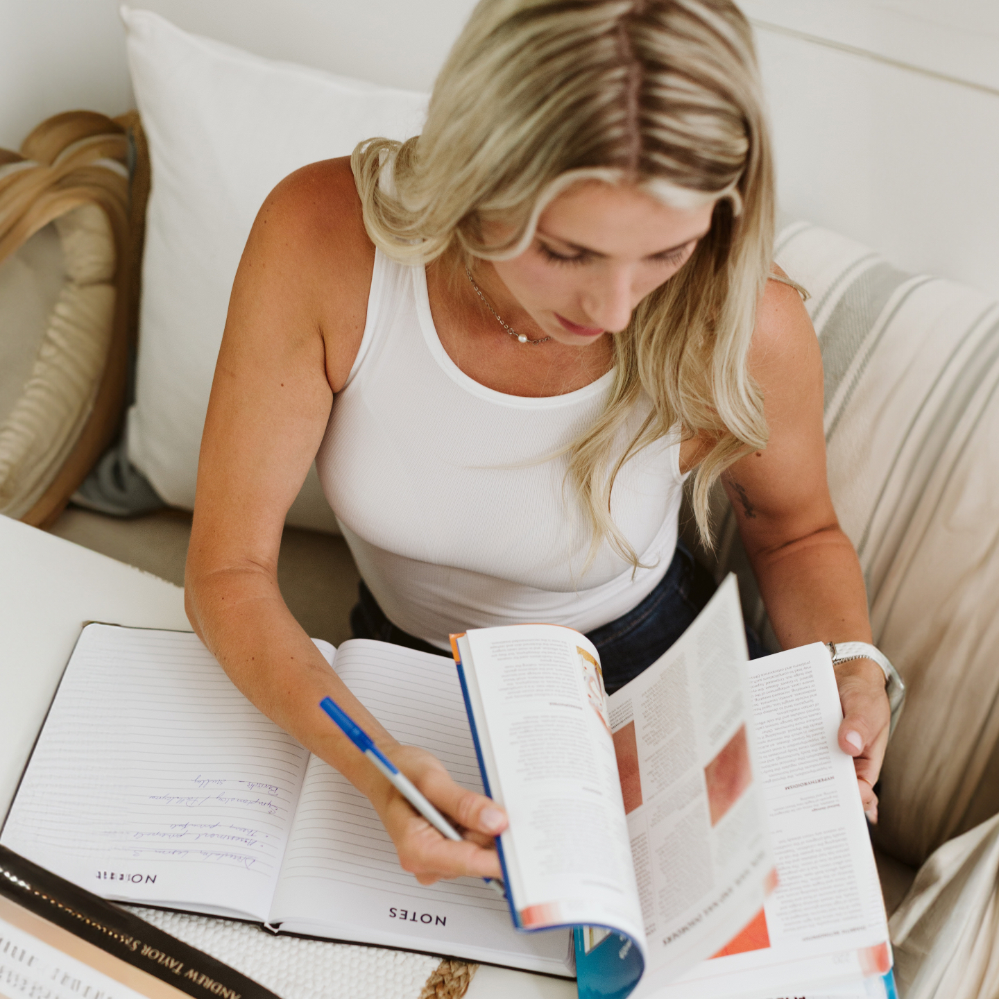 Woman studying in a textbook and taking notes.