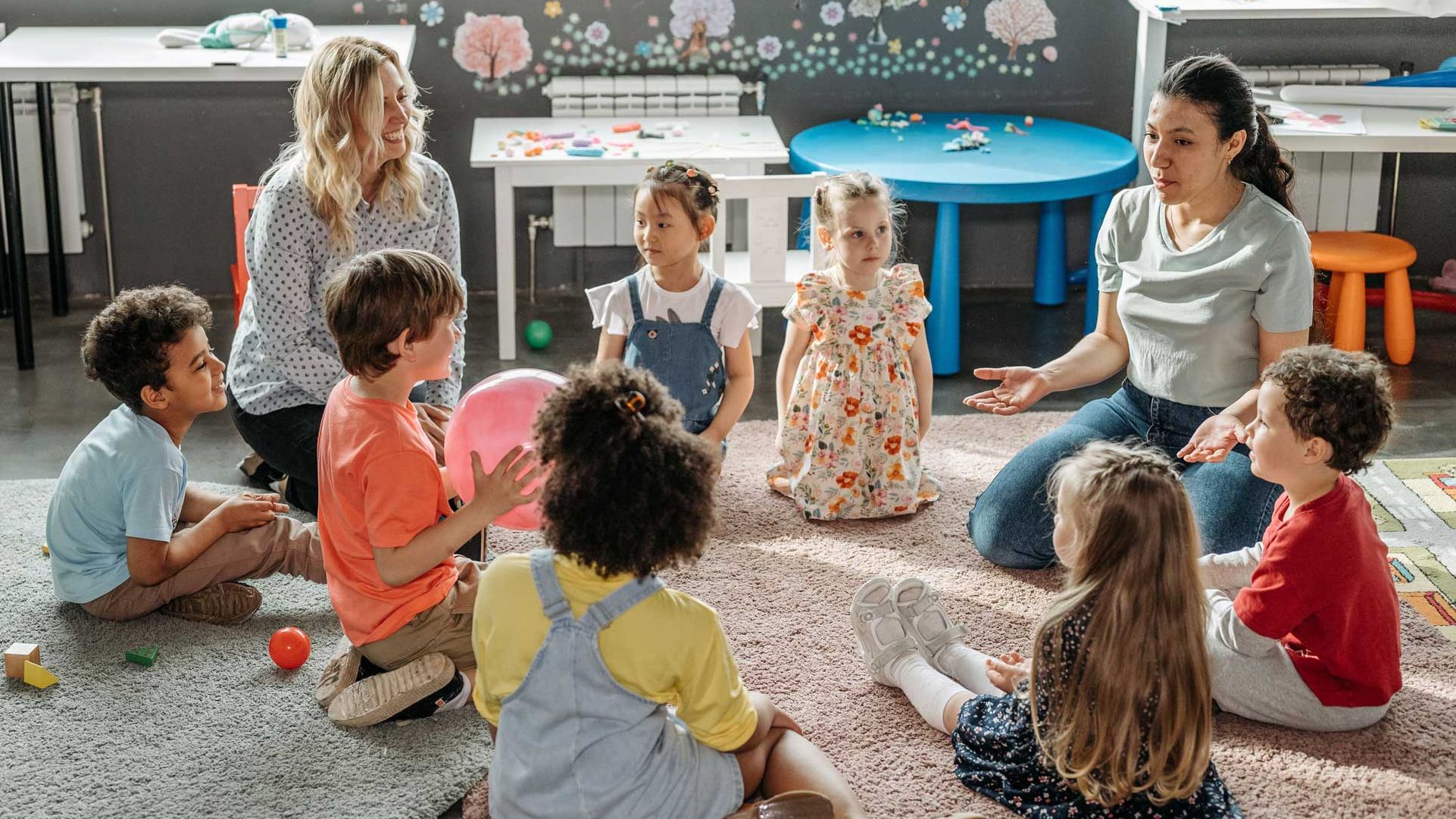 Woman teaching a young boy and girl about patience through taking turns during play
