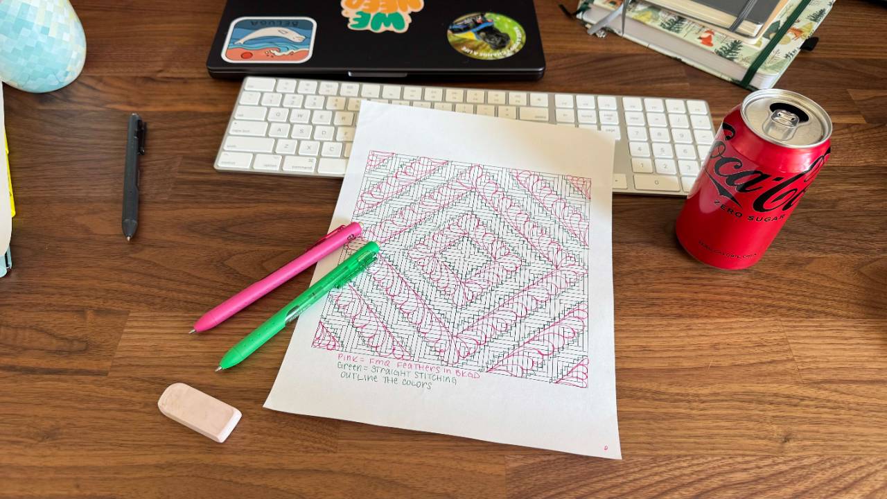A printed coloring sheet from the Harvest Light quilt pattern with pens, an eraser, and my signature Coke Zero on a wooden desk.