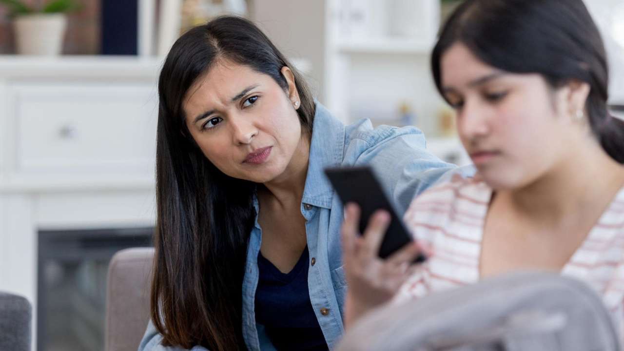 Parent reconnecting with emotionally disconnected teenager during a supportive conversation at home