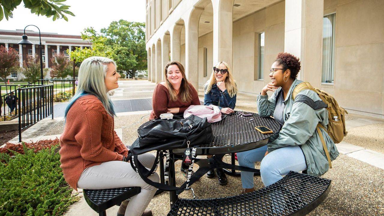College students enjoying a conversation outdoors and building friendships on campus
