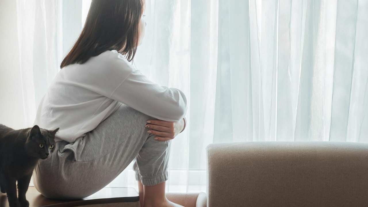 Teen girl looking out window feeling disconnected, overwhelmed, and uncertain about her future