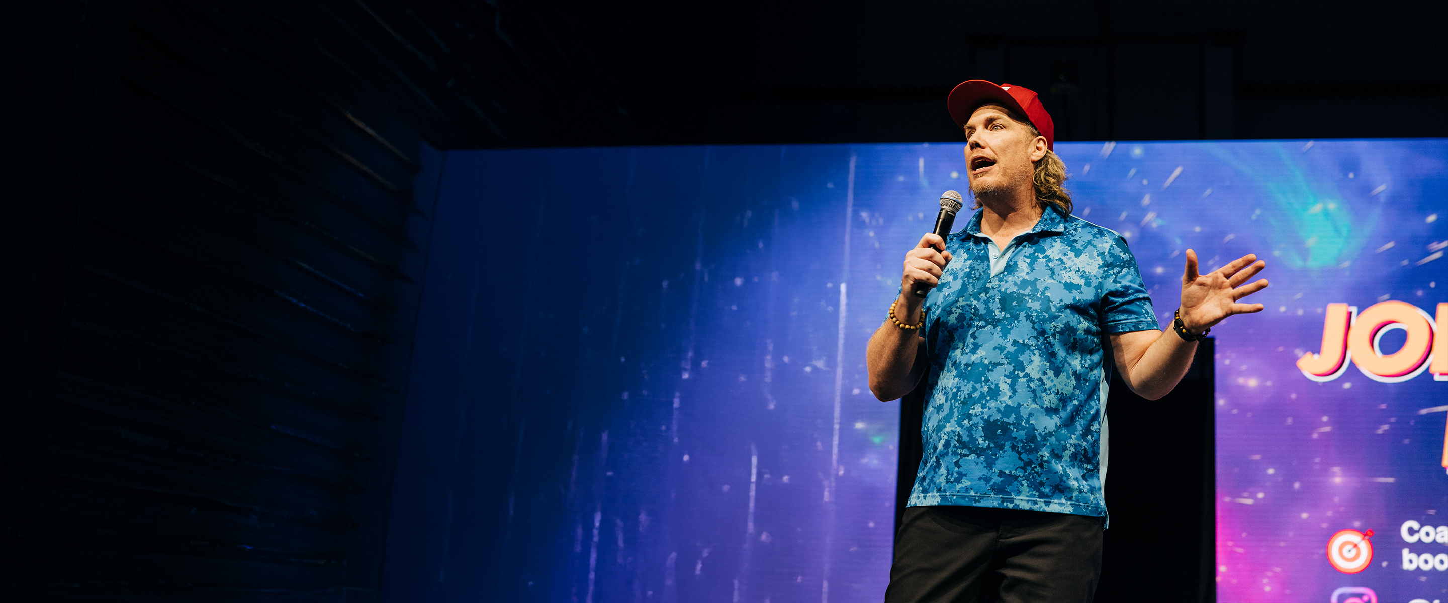 Joey Freddy Larsen performing and speaking onstage at Business By Design Live