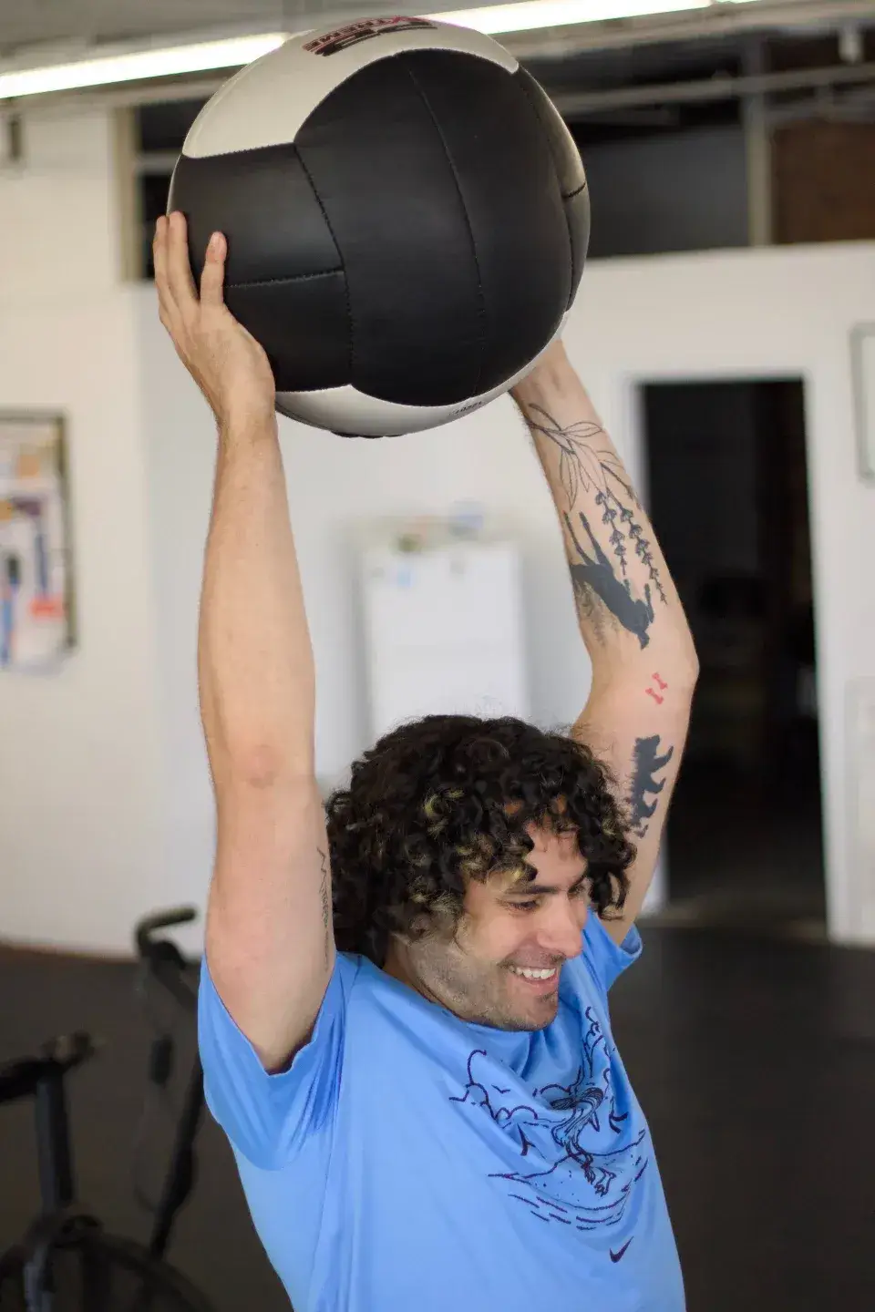 TIWL Member over head slamming a medicine ball