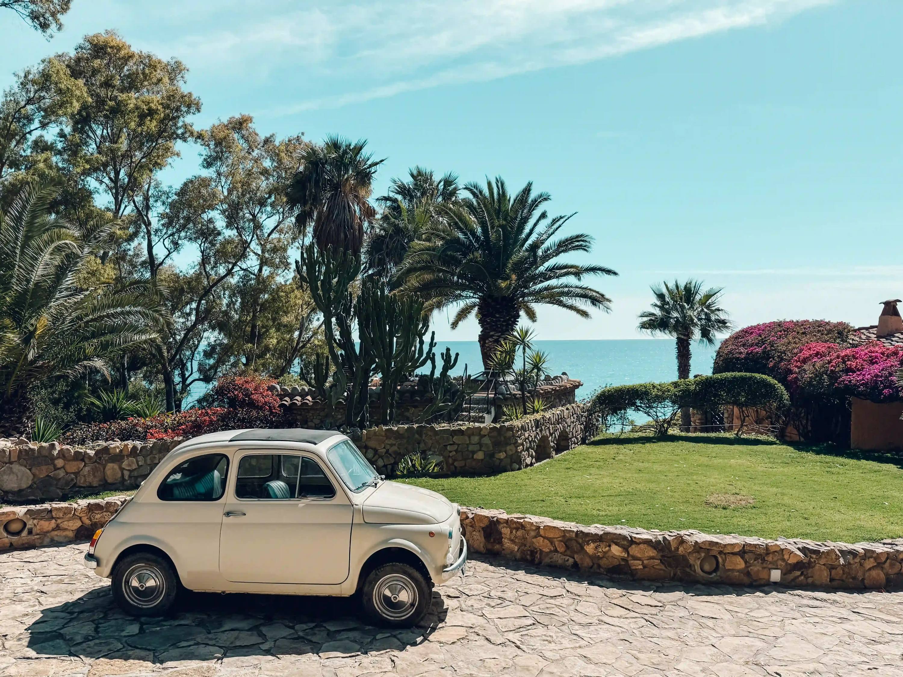 Vintage cream Fiat 500 parked by the sea in Sardinia