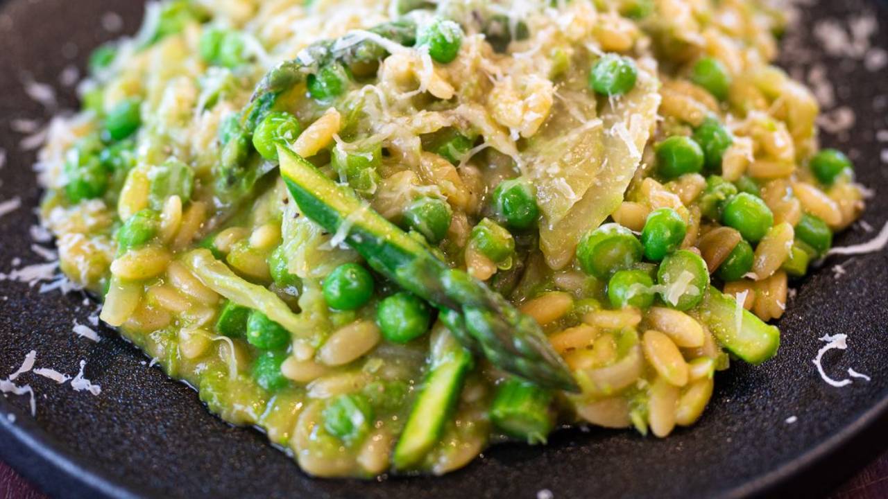 Creamy green risoni with whole peas and asparagus tips, finished with grated parmesan and black pepper