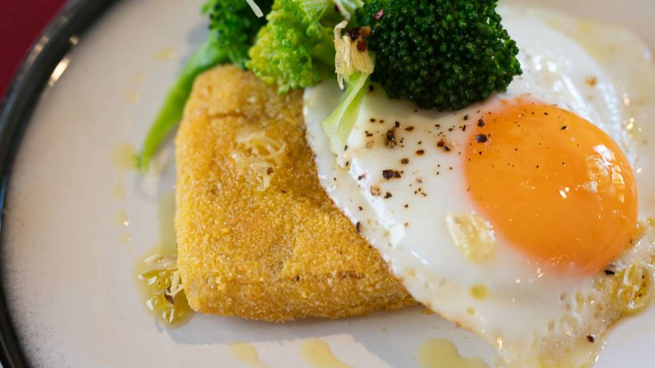 Crispy air fryer polenta cake with a fried egg, broccoli and chilli garlic oil poured over