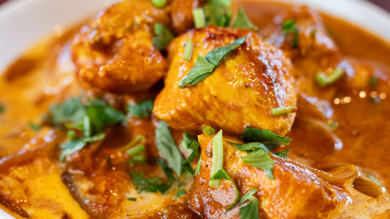 Creamy homemade butter chicken curry in a pan garnished with fresh coriander ready to serve with rice