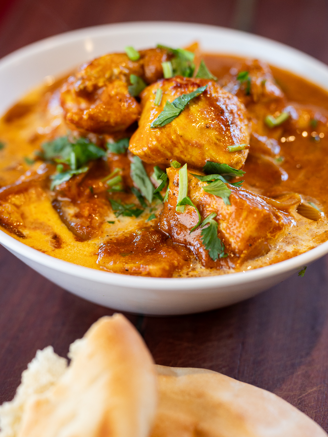 Creamy homemade butter chicken curry in a pan garnished with fresh coriander ready to serve with rice