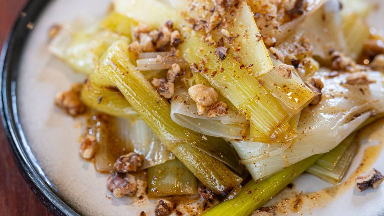 Charred leeks pulled into soft strips, drizzled with red harissa oil and scattered with toasted nuts