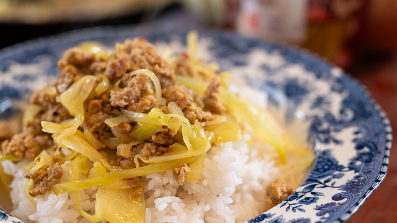 Curried pork mince and cabbage served over steamed white rice in a bowl