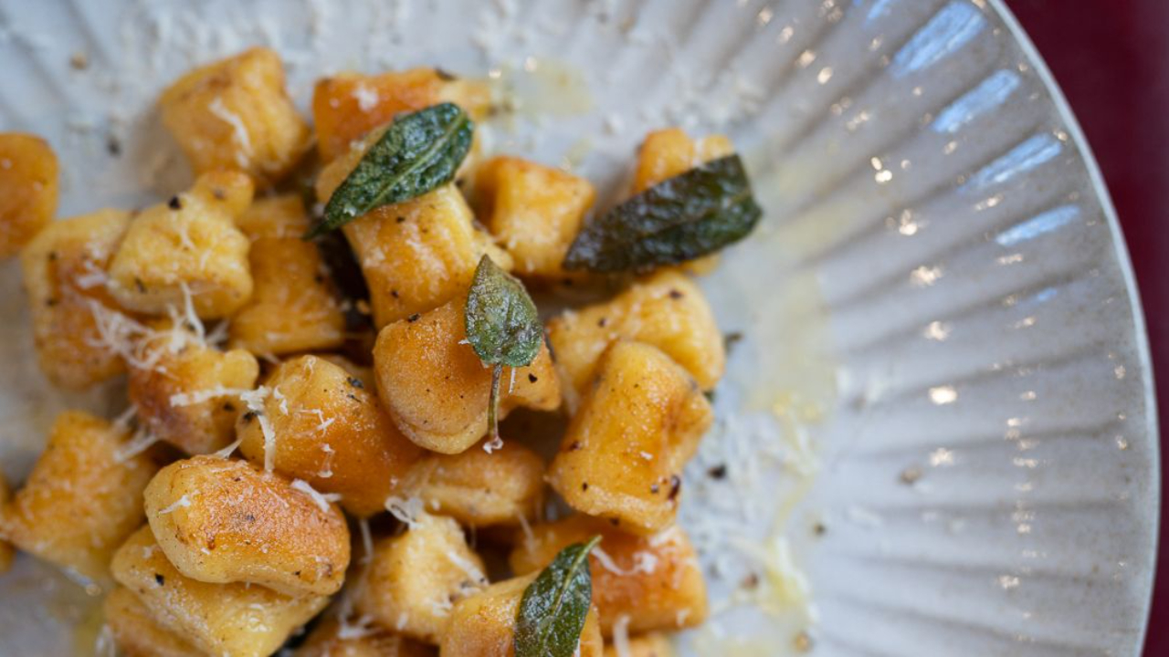 Golden, crispy gnocchi parisienne in a pan with brown butter and crispy sage leaves, finished with grated parmesan and black pepper