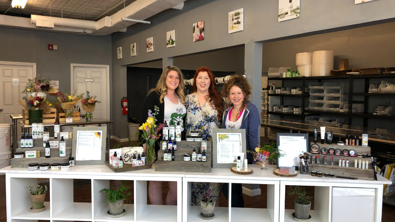 three white women in a commercial space surrounded by beauty products 