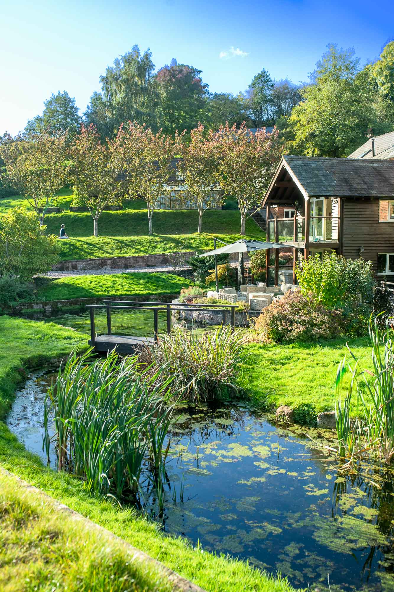 Pond, reeds and a wooden footbridge in the retreat grounds