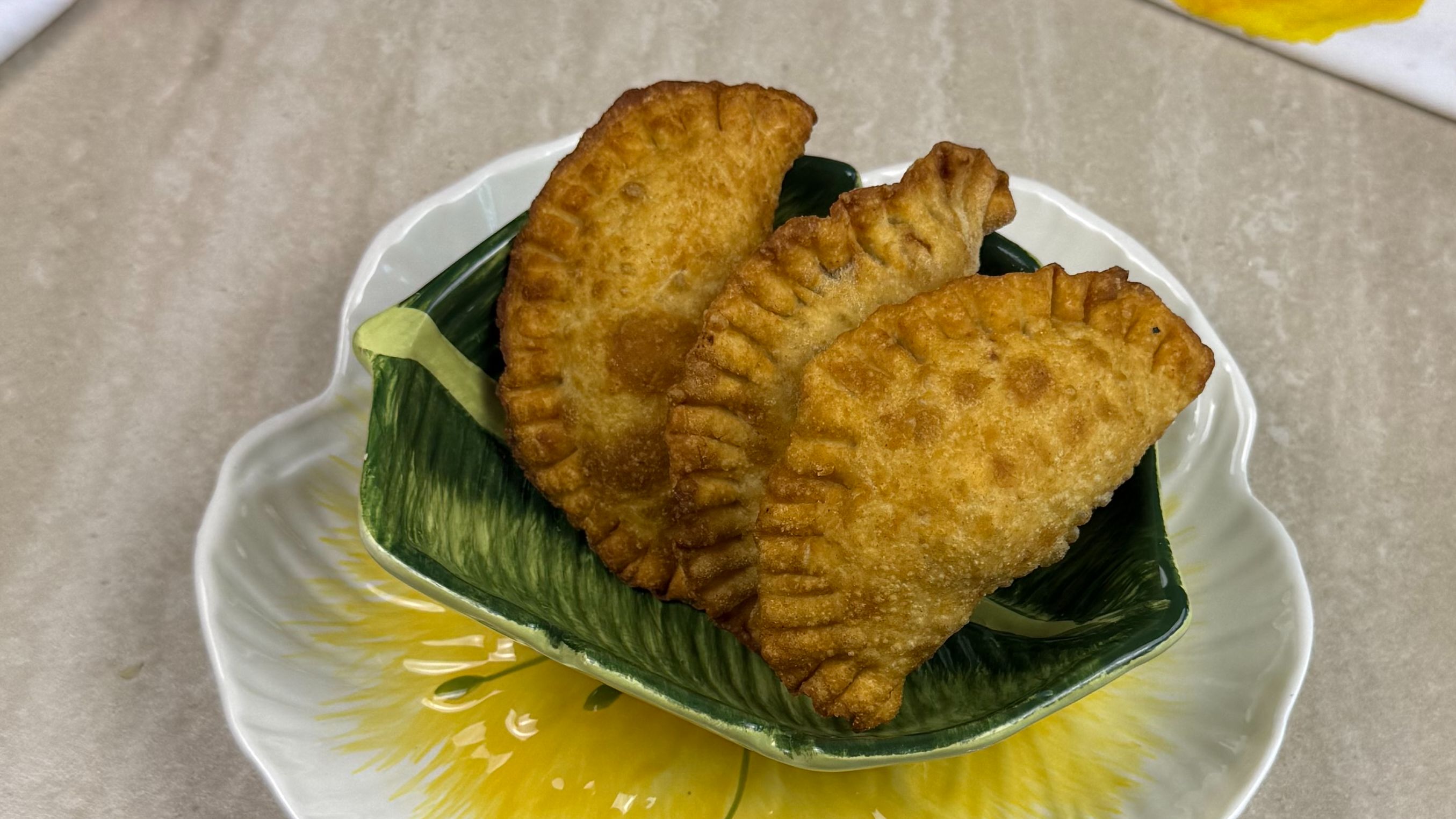 empanadas de lambí sobre un plato en forma de hoja verde