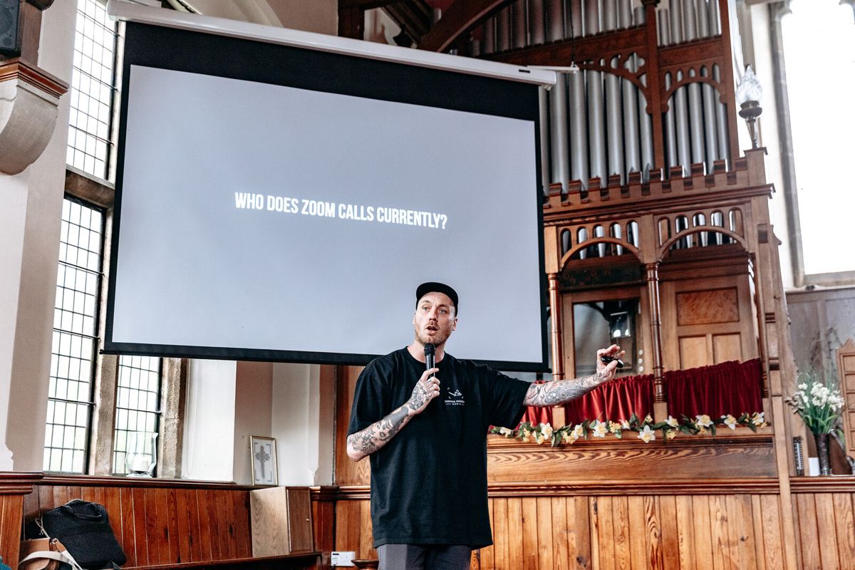 Josh teaching a room of wedding photographers in front of a projector screen