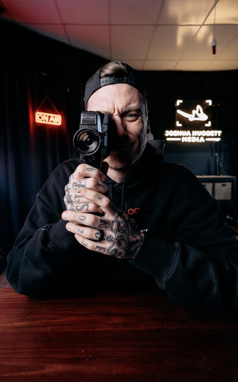 Josh Huggett holding a vintage film camera up to his eye