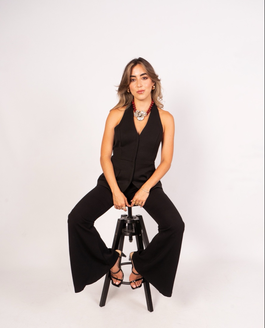Gabriela Ferrando sentada en un banco con traje negro
