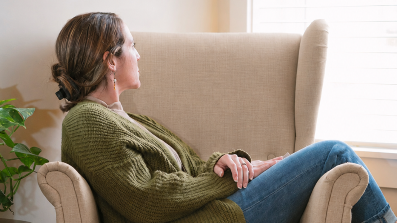 A woman sitting quietly, reflecting after betrayal trauma and seeking clarity about truth and disclosure.