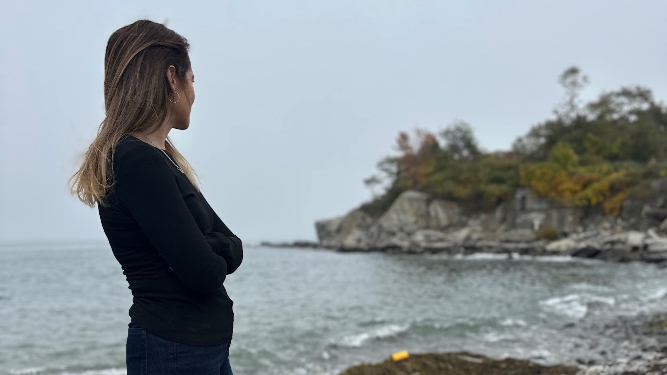 Woman standing by the ocean reflecting during betrayal trauma healing journey
