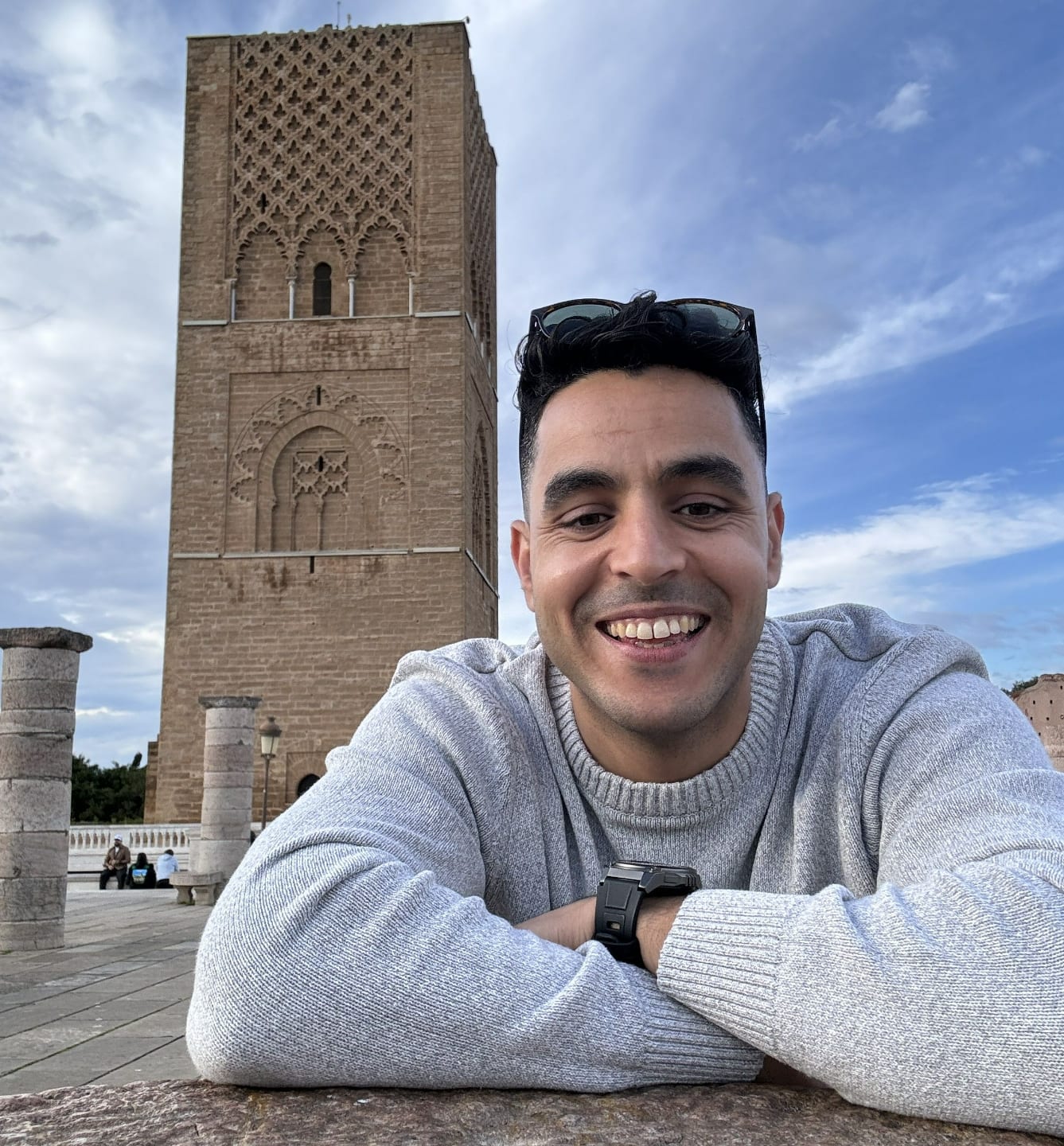 Abdul, native Moroccan Arabic teacher, smiling in front of the Hassan Tower in Rabat