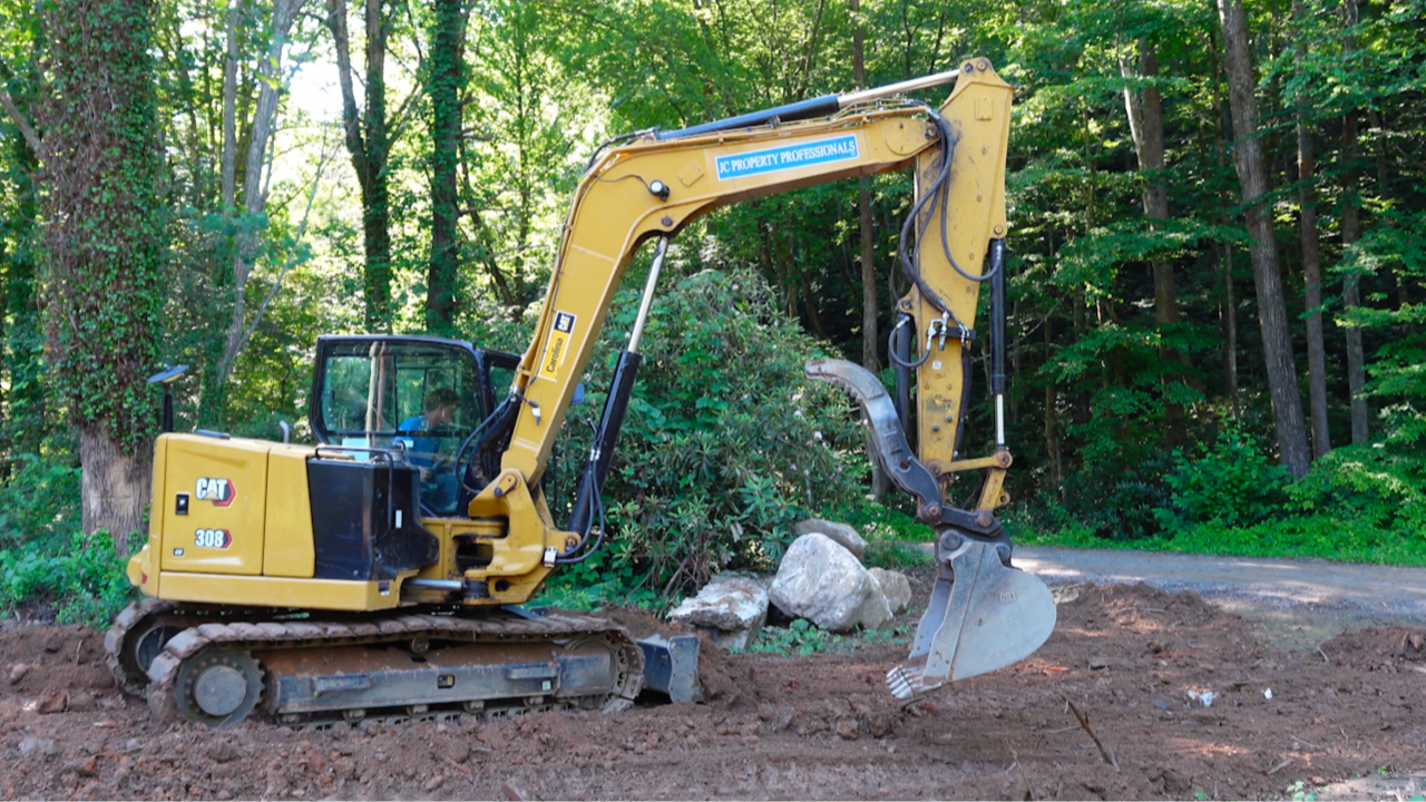 JC Property Professionals trackhoe working.