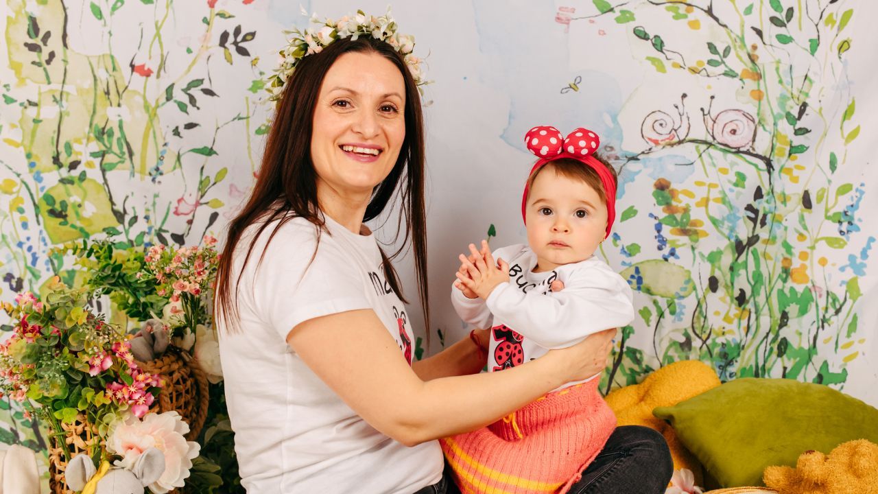 Mamă ținându-și copilul în brațe într-un moment autentic de liniște și conexiune emoțională în viața de zi cu zi.