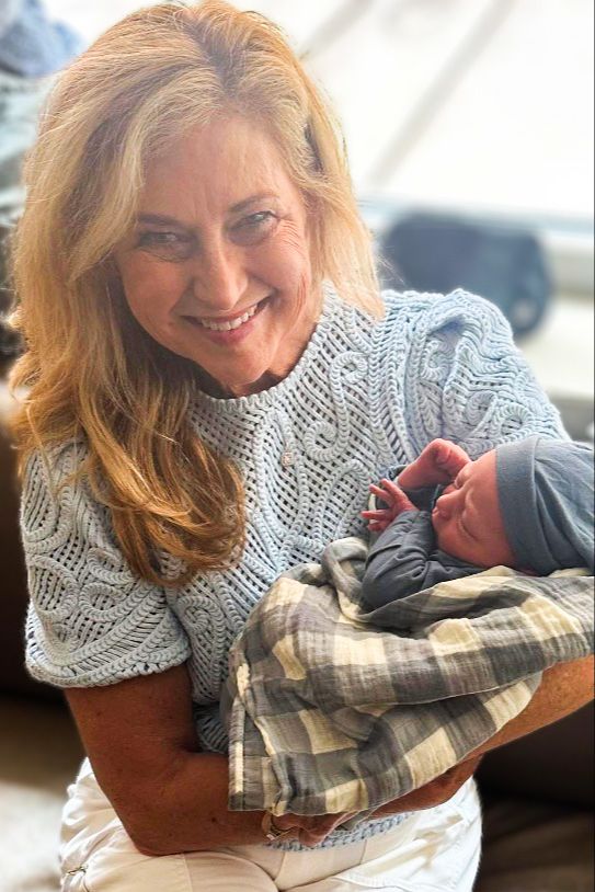 Snapshot of a smiling woman holding her grandchild.