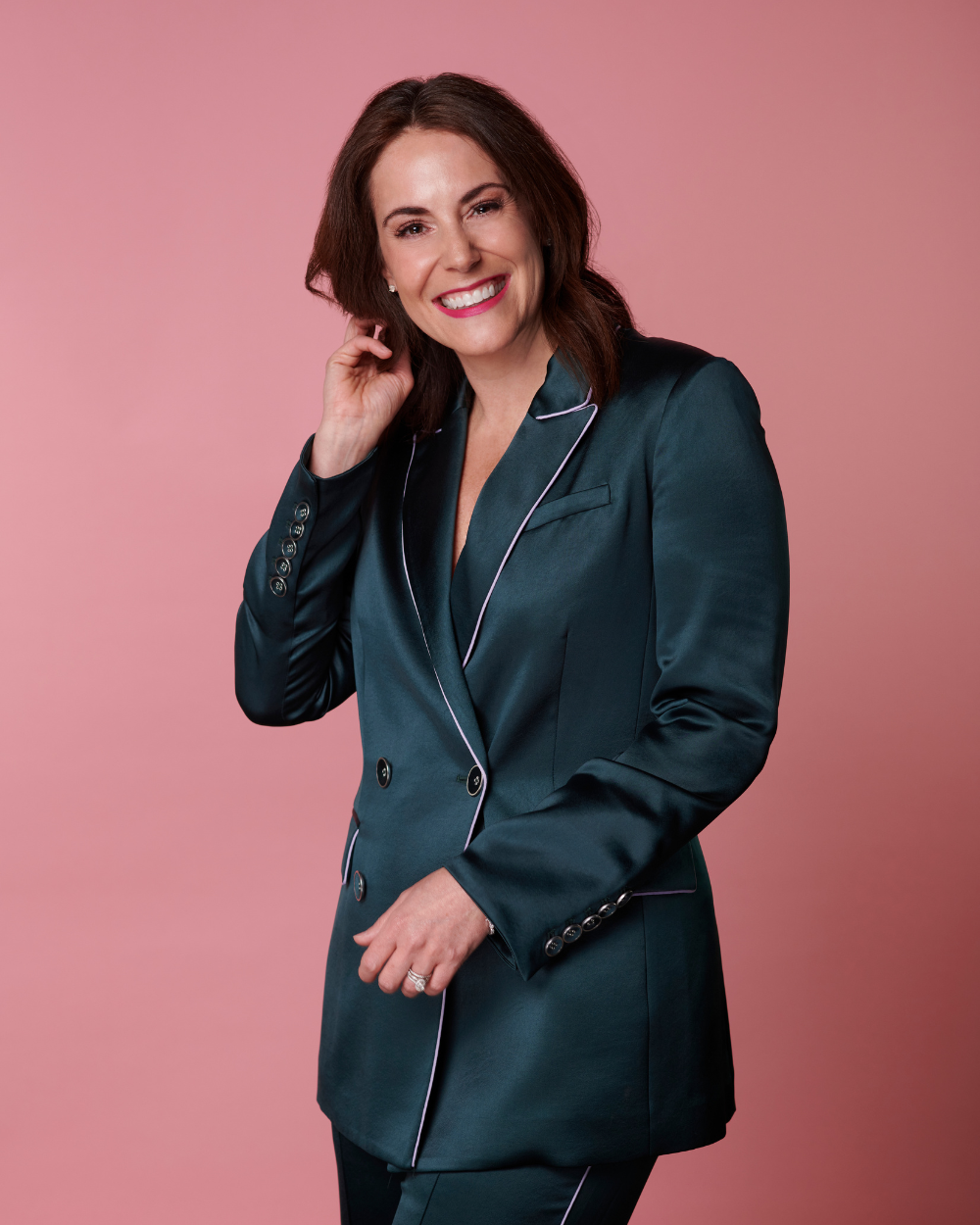 Tiffany Sauder, smiling, in a teal suit against a pink background