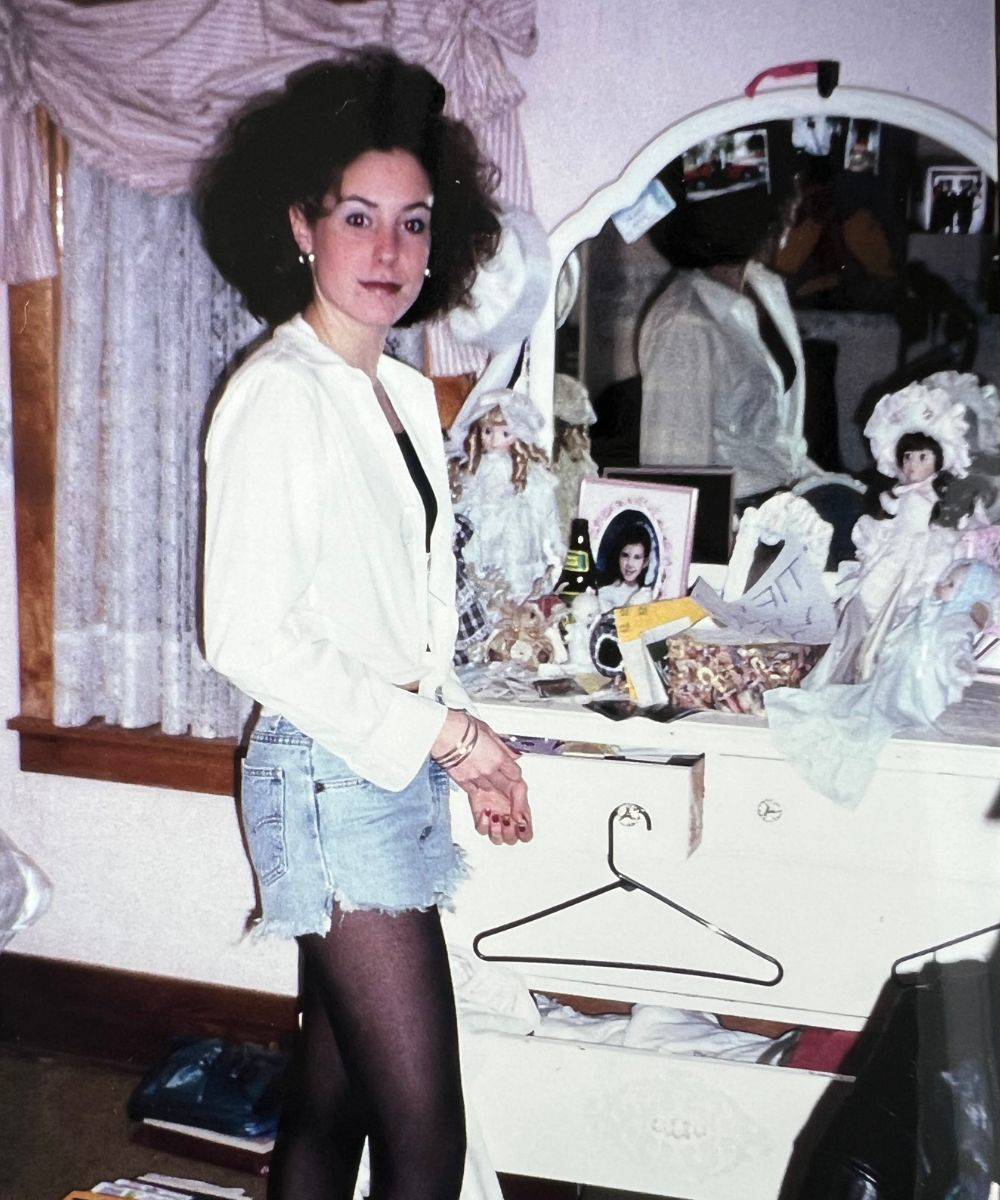 Teenage Tiffany with big curly hair, standing in her bedroom.