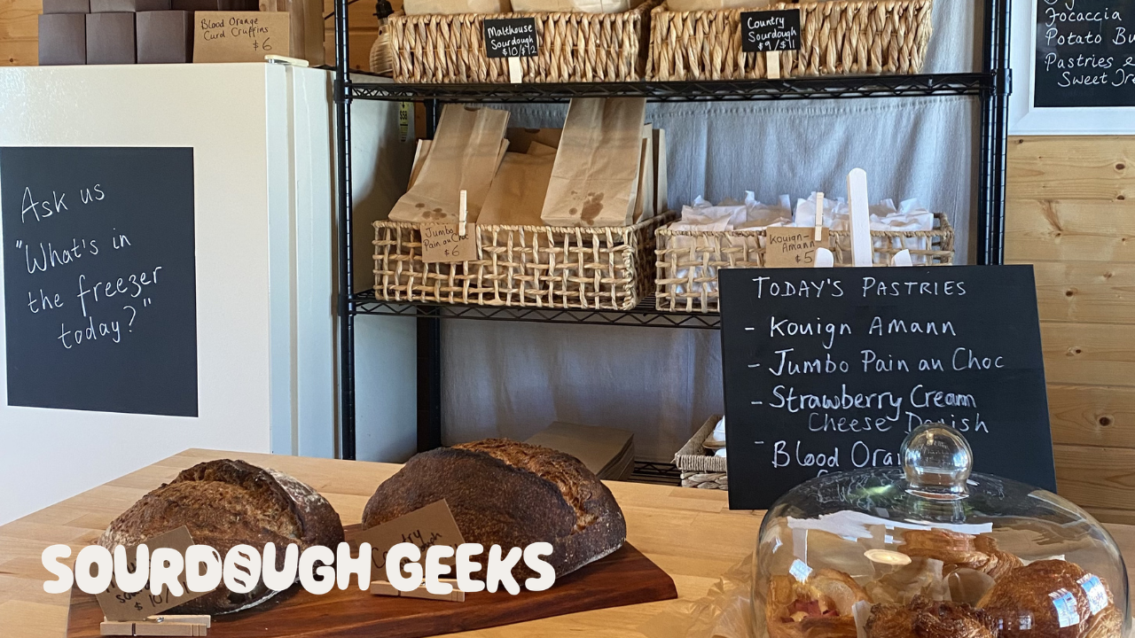 inside a sourdough bakery hut; display, signage & stock, and a freezer with a blackboard panel 