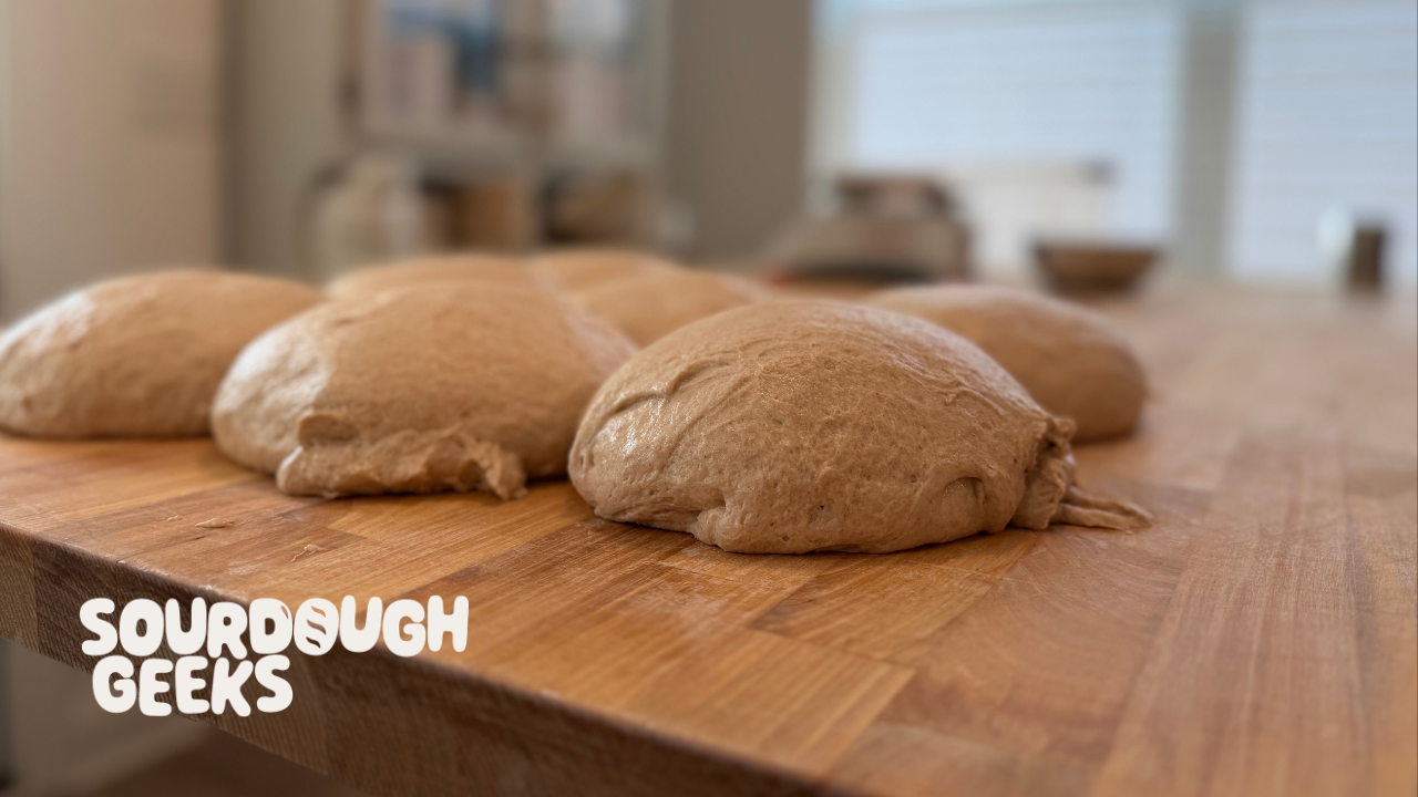 a butcher block wooden sourdough bakers bench with dough on it