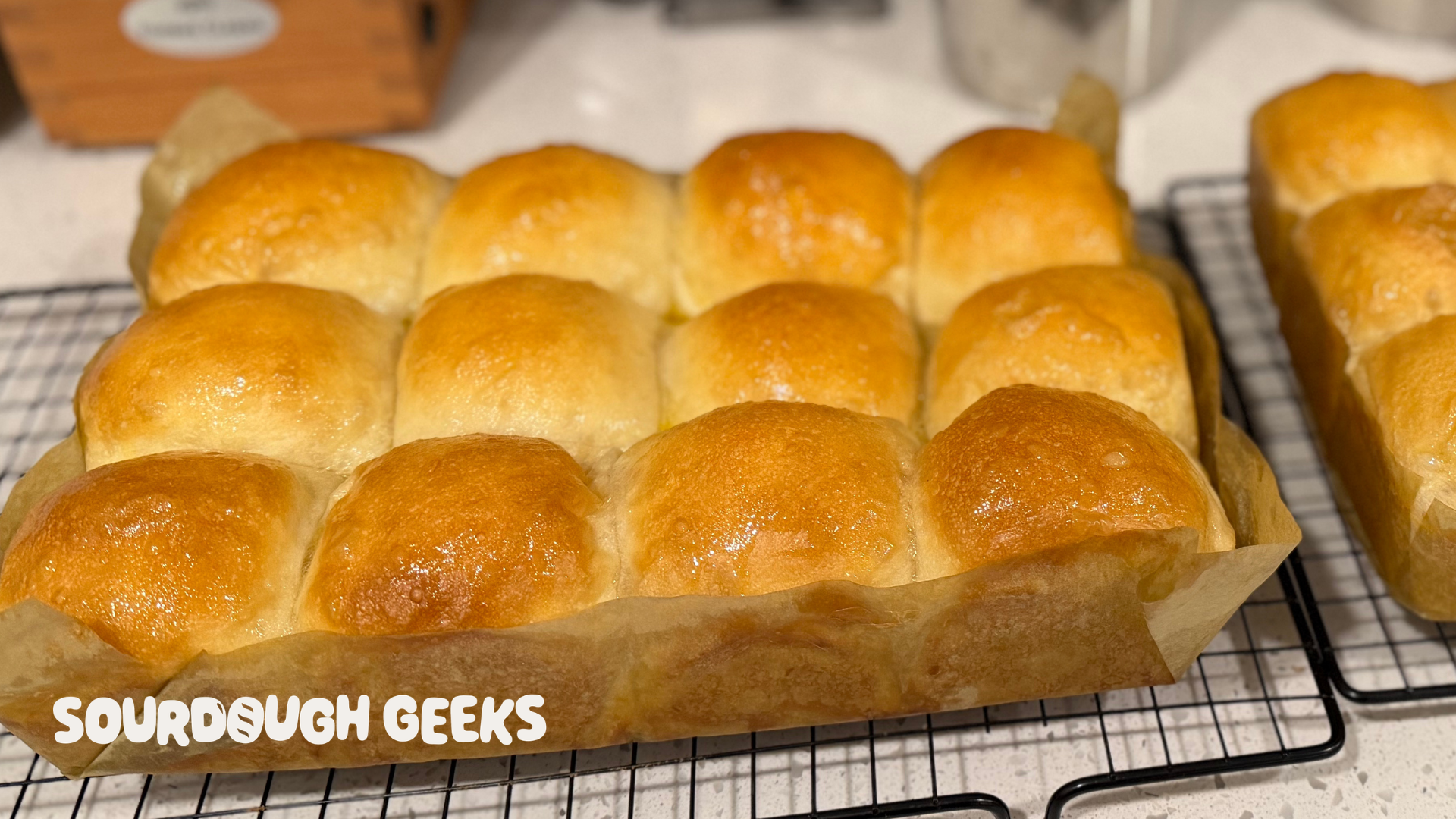 Sourdough Dinner Rolls, baked and glazed, cooling on a wire rack
