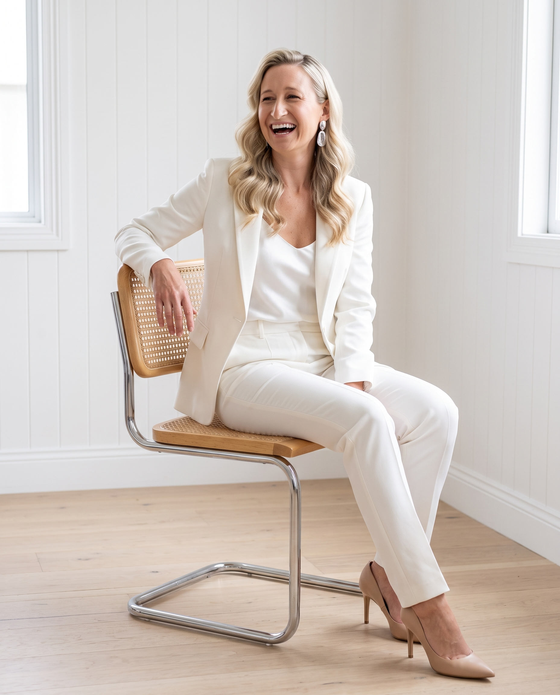 Brigette Coles in a cream suit, laughing