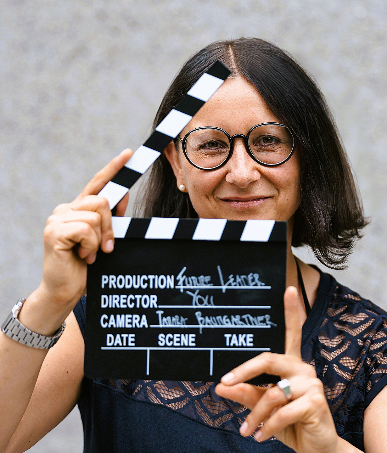 tamara-baumgartner-business-coaching-fuer-future-of-work-by-baumgartner-business-coaching-mit-filmklappe-in-der-hand-wo-future-leader-you-steht
