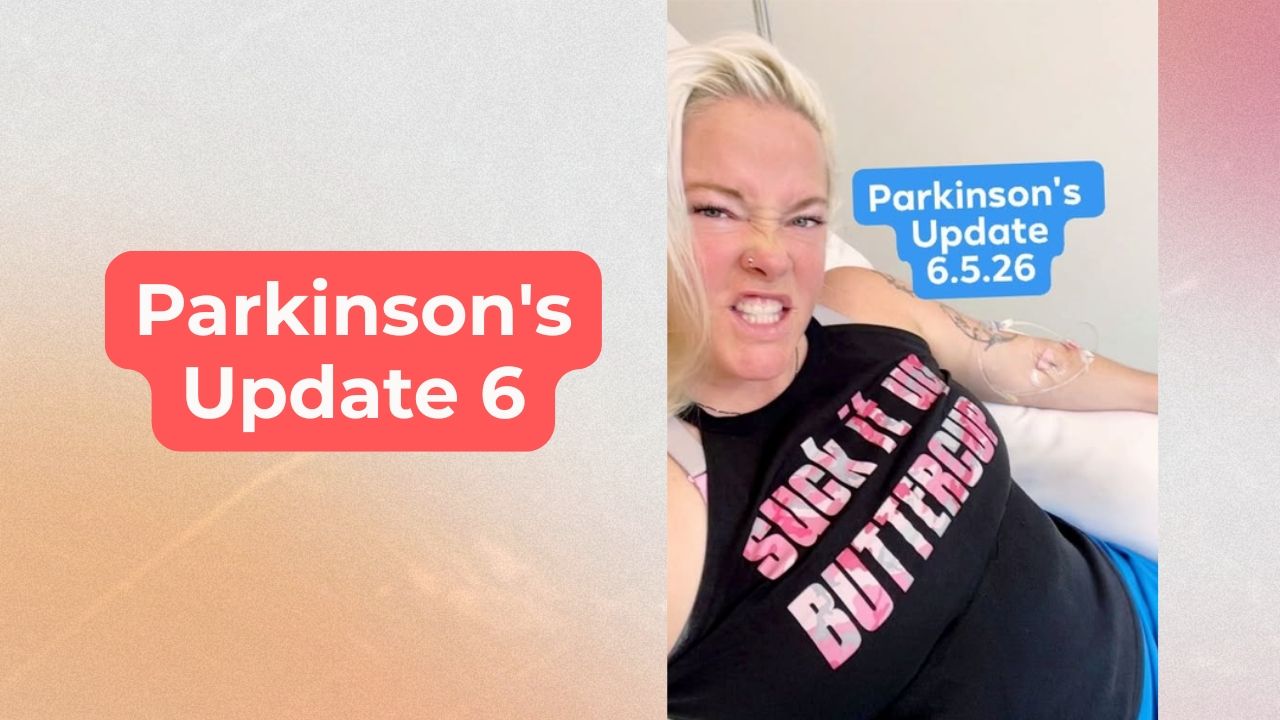 Woman smiling, wearing a black shirt with words that say "suck it up buttercup" with and IV in her arm and words on the screen that say, "Parkinson's Update 6" and "Parkinson's Update 6.5.26"
