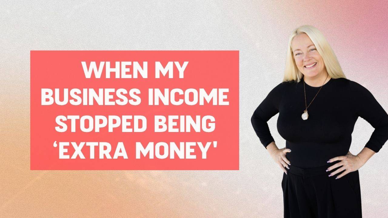 Blonde woman in black long sleeve shirt and black jeans wearing a gold necklace, smiling, and posing with her hands on her hips and words on the screen that say, "When My Business Income Stopped Being ‘Extra Money'"
