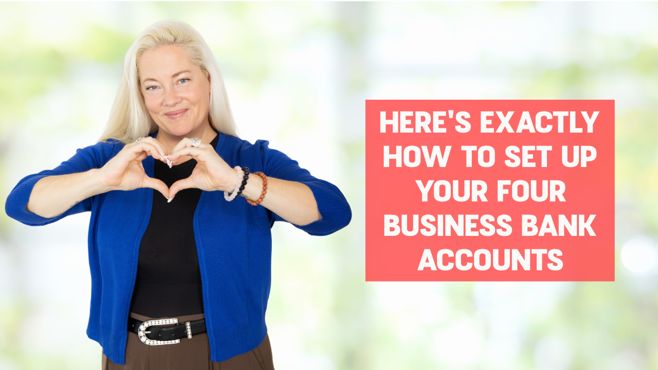 Woman wearing a black shirt with brown pants and a royal blue cardigan smiling and making a heart shape with her hands with words on the screen that say, "Here's Exactly Hot to Set Up your four Business Bank Accounts"