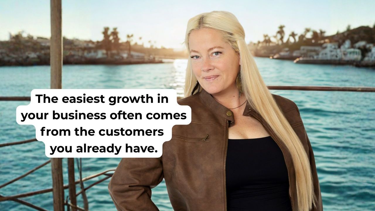 woman in brown leather jacket smiling with words on the screen that say "The easiest growth in your business often comes from the customers you already have."
