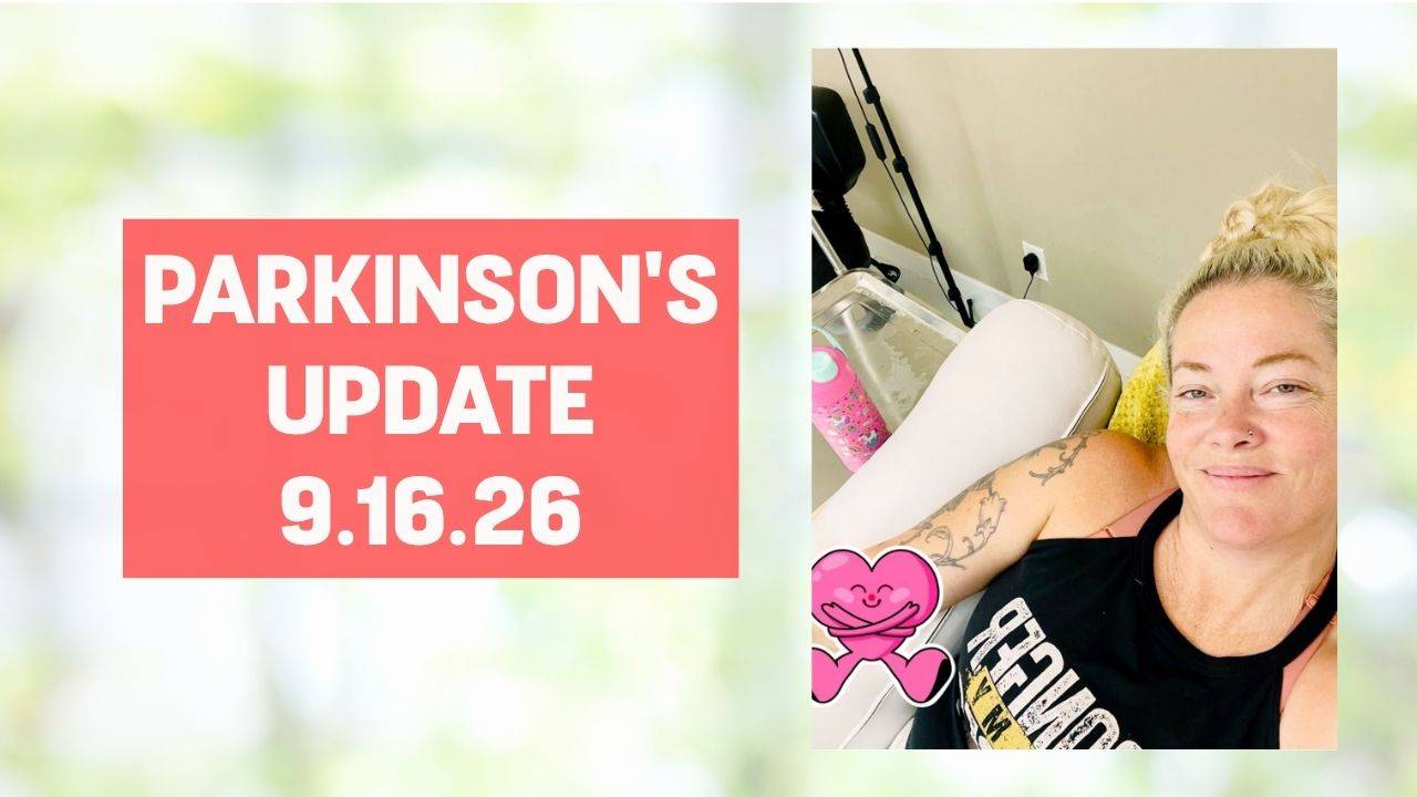 Blonde woman in a black tank top smiling and with a heart sticker emoji on her arm smiling with words on the screen that say, "Parkinson's Update 9.16.26"